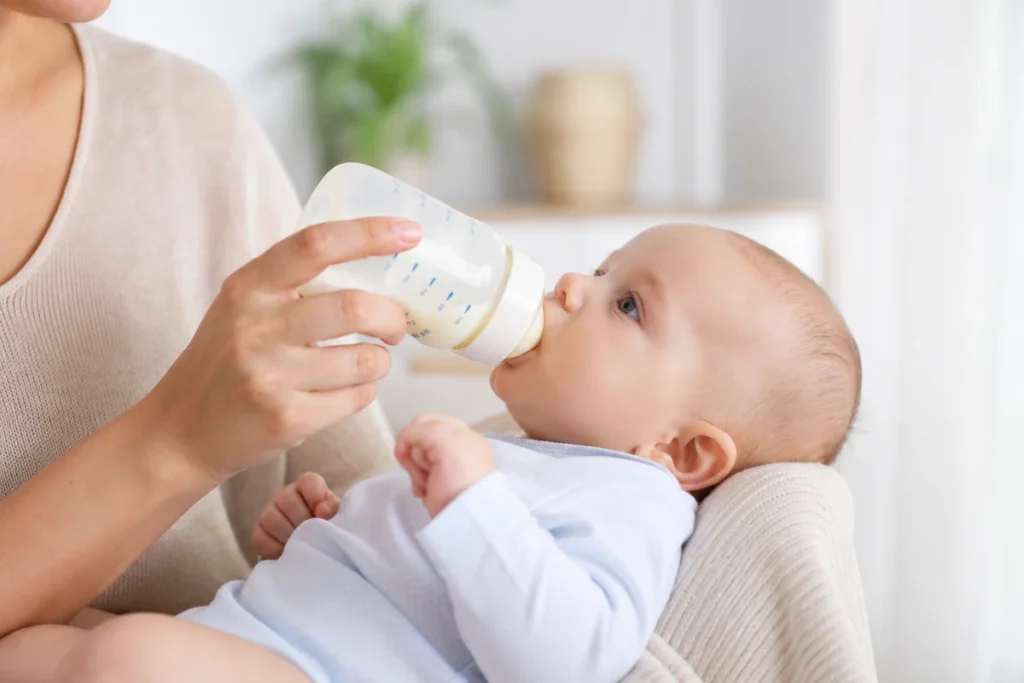 Bottle-feeding an infant using proper feeding techniques to help manage reflux and reduce discomfort.
