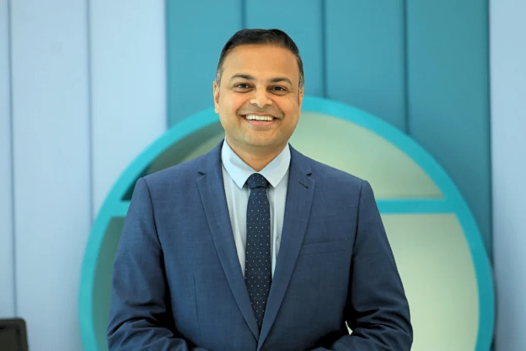 Dr. Mahesh Katre, a UK-trained paediatric allergy specialist in Dubai, smiling in a suit.
