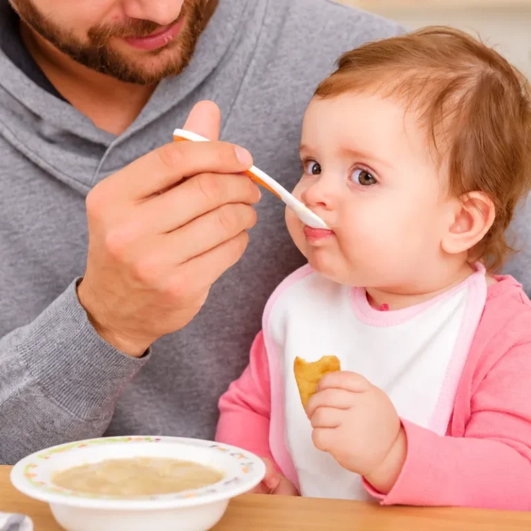 how long does oral immunotherapy take- Parent feeding a baby with a spoon, illustrating parental support and feeding routines during childhood food allergy care.