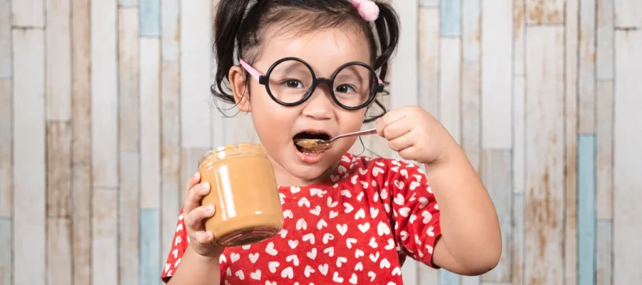 Child eating peanut butter as part of peanut oral immunotherapy